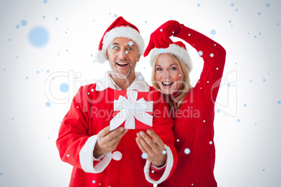 Festive couple smiling and holding gift