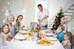 Composite image of family having christmas meal at dining table