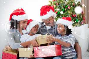 Composite image of family holding christmas gifts