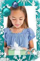Composite image of cute little girl holding a wrapped gift