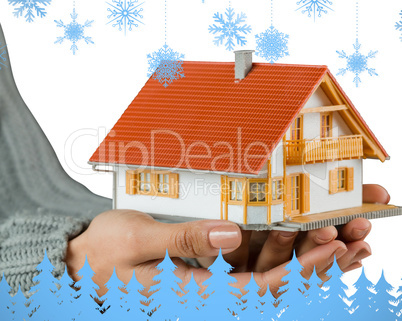 Composite image of hands showing a miniature model home