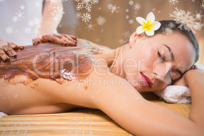 Attractive woman receiving chocolate back mask at spa center