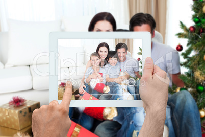 Composite image of hand holding tablet pc