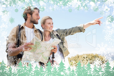 Attractive hiking couple reading the map on mountain trail