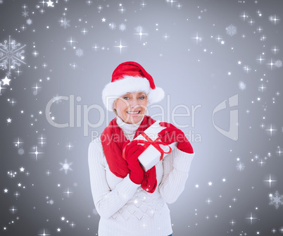 Composite image of festive woman holding gift