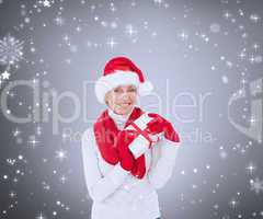 Composite image of festive woman holding gift