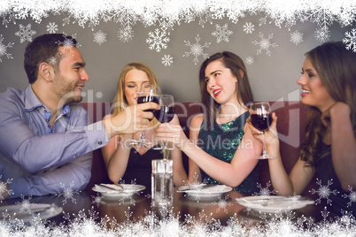 Composite image of friends clinking red wine glasses at a bar