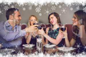 Composite image of friends clinking red wine glasses at a bar