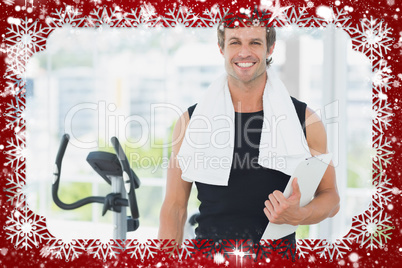 Smiling male trainer with clipboard in bright gym