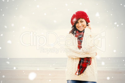 Cute smiling woman in stylish warm clothing at beach