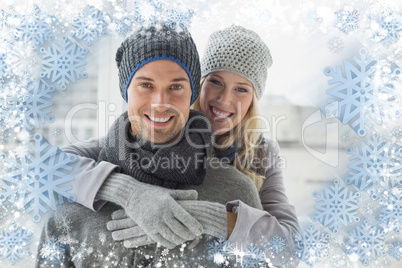 Cute couple in warm clothing hugging smiling at camera