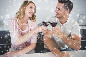 Composite image of couple toasting red wine glasses at table