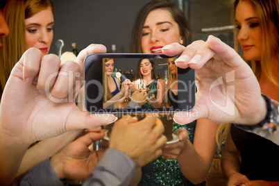 Composite image of hand holding smartphone showing