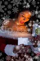 Pretty brunette in santa outfit opening gift