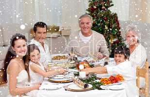 Composite image of children pulling a christmas cracker at home
