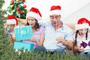 Composite image of family opening christmas presents