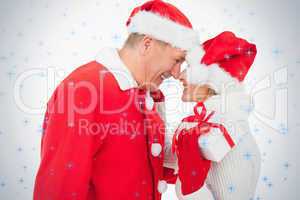 Festive older couple smiling at each other and holding gift