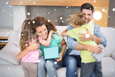 Young siblings giving presents to their parents