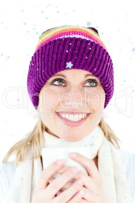Composite image of merry young woman holding a cup wearing a cap