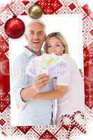 Composite image of happy couple flashing their cash
