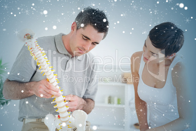 Chiropractor and patient looking at a model of a spine