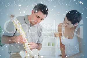 Chiropractor and patient looking at a model of a spine