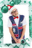 Composite image of geeky hipster in santa hat