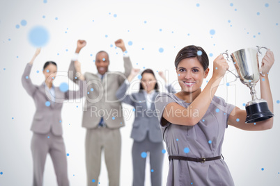 Woman holding up a cup with enthusiastic coworkers