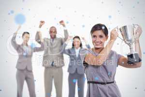 Woman holding up a cup with enthusiastic coworkers