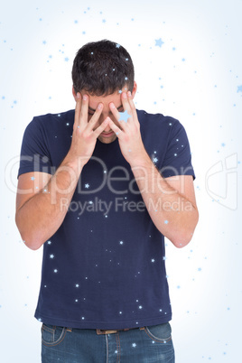 Upset man standing with his head in hands