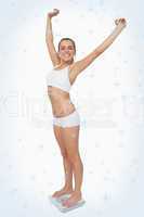 Composite image of happy slim woman standing on a scales spreading her arms