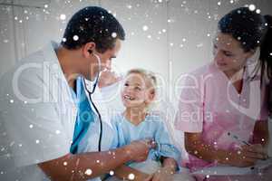 Composite image of a doctor and a nurse examining a little girl