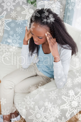 Woman with headache sitting on sofa