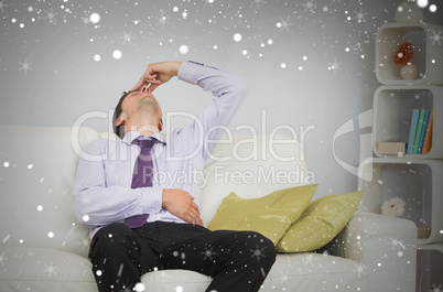 Tired businessman sitting on sofa in living room