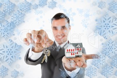 Close up of keys and miniature house being held by male estate agent