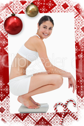 Slim young woman smiling while sitting on a scales