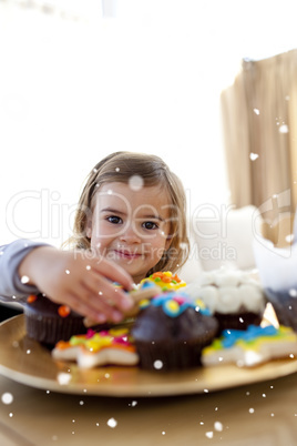 Composite image of smiling little girl eating confectionery at h