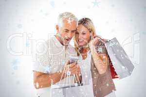 Happy couple holding shopping bags and smartphone