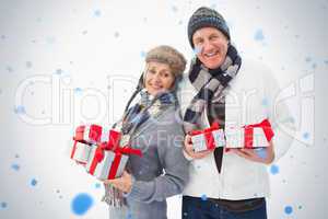 Mature couple in winter clothes holding gifts