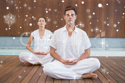 Peaceful couple in white sitting in lotus pose together