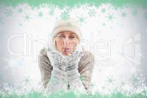 Mature woman in winter clothes blowing kiss