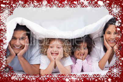Composite image of family hiding under the blanket
