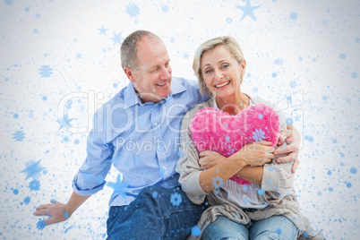 Happy mature couple with heart pillow