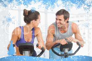 Smiling young couple working out at spinning class