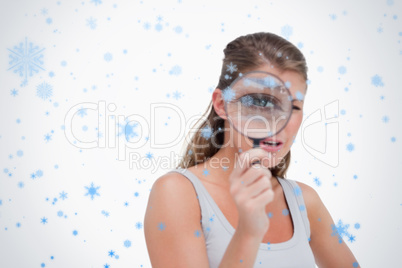 Young woman looking through a magnifying glass