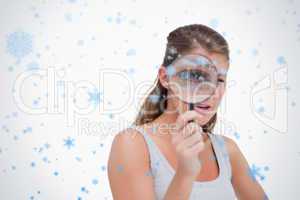 Young woman looking through a magnifying glass