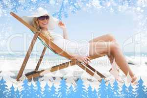 Gorgeous blonde sitting at the beach wearing sunhat and sunglass