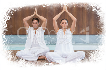Attractive couple in white sitting in lotus pose with hands together