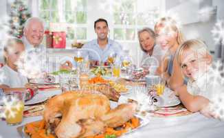 Composite image of focus on the roast turkey in front of family