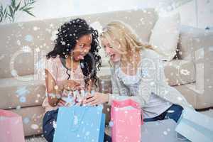 Two women looking at clothes in shopping bags